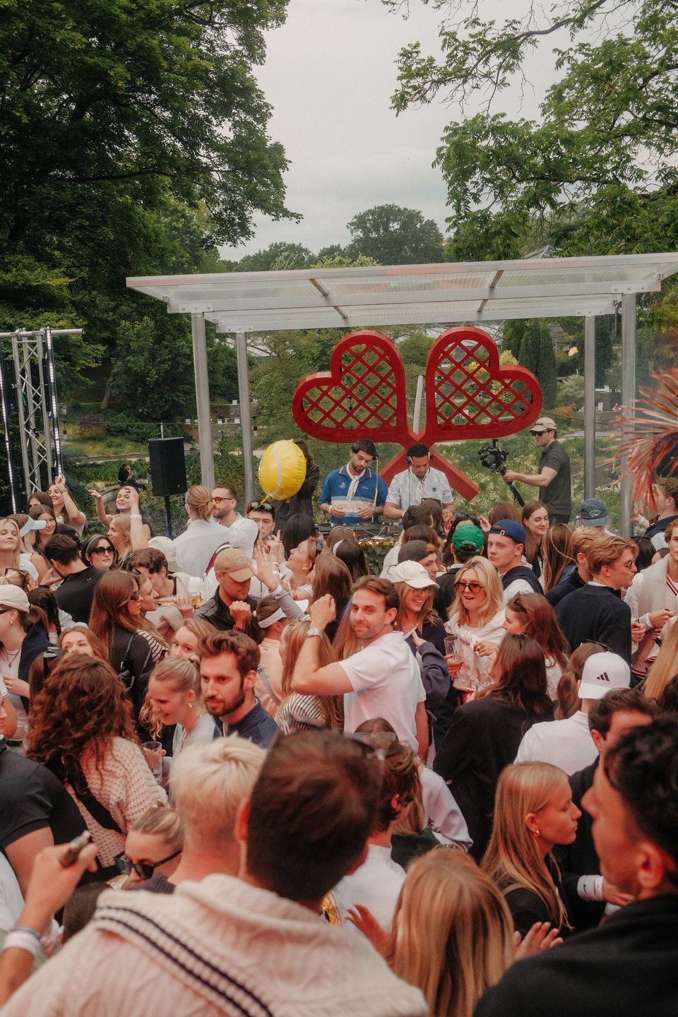 Dichte Crowd vor der Pergola-Bühne mit Herzschlägern im Garten