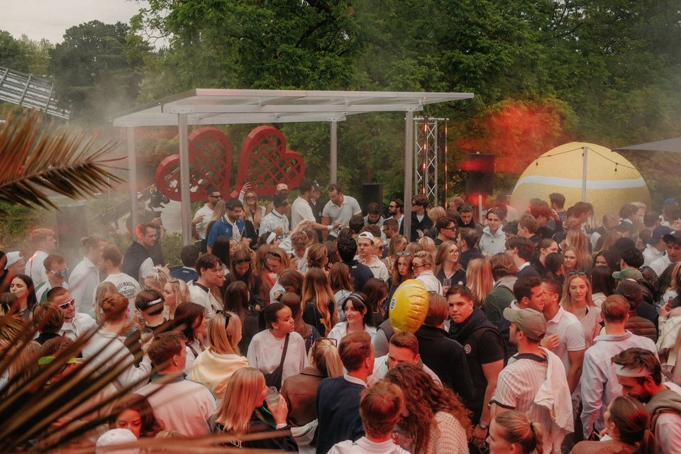 Party im Garten: Rauch, Herzschläger-Bühne und Riesenball über einer dichten Crowd