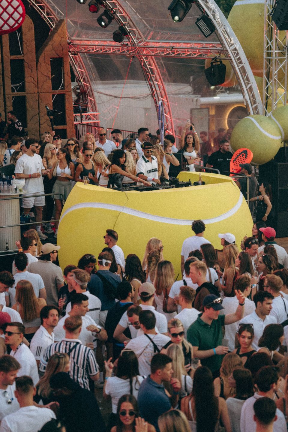 Dichte Crowd in Weiß rund um das riesige Tennisball-Pult