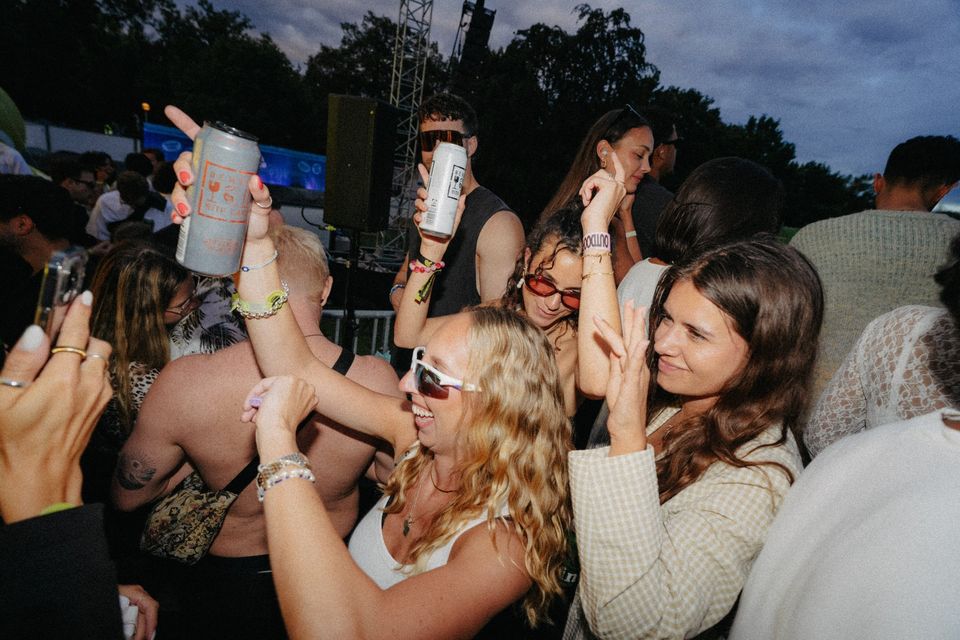 Freundinnen tanzen mittendrin in der Crowd vor der Fifteen Love Stage, Dosen in die Luft gereckt
