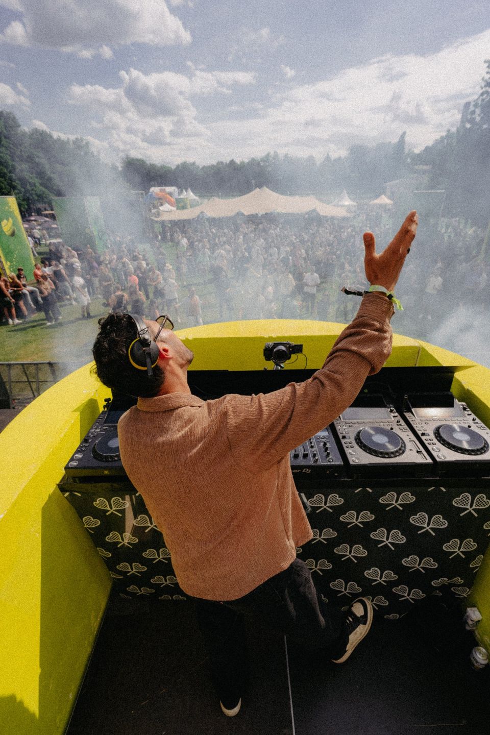 DJ legt den Kopf in den Nacken, CO2-Nebel steigt über der Crowd auf