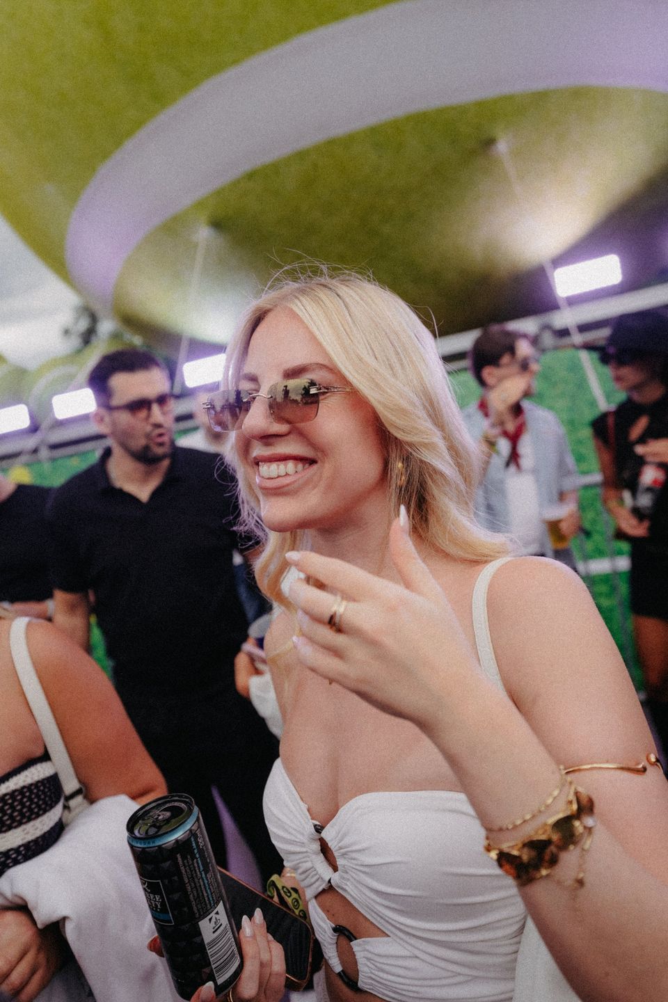 Blonde Frau in Weiß lacht unter dem großen Ball-Baldachin der Fifteen Love Stage
